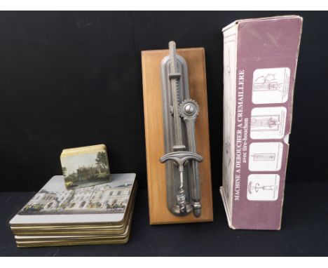 A wall-mounting single-action corkscrew (boxed and unused) together with a set of 12 place mats and 10 coasters:1. the restau