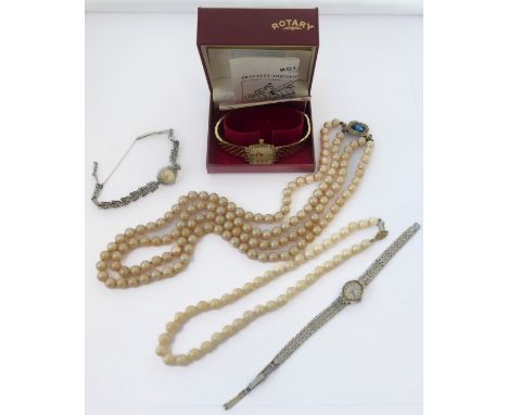 A mixed lot comprising three lady's wristwatches and two strings of pearls. The watches comprising a gold-plate-cased example
