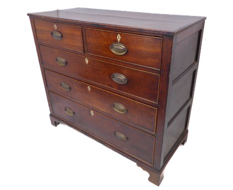 An early 19th century oak chest: the reeded edge top; two half-width and three full-width graduated drawers with Anglesey-sty
