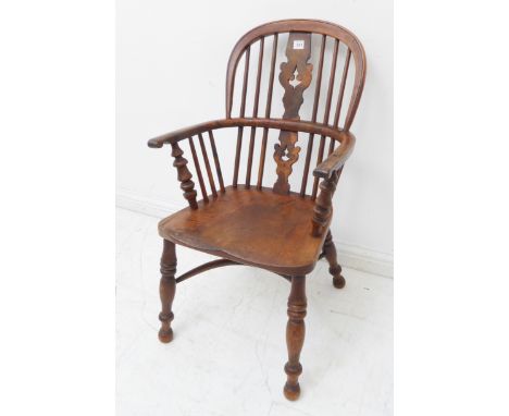 An unusual mid 19th century child's comb back Windsor armchair: yew wood bow and splat, shaped elm seat and turned slightly s