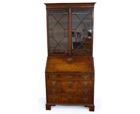 An 18th century mahogany bureau bookcase: the associated top with two thirteen panel astragal glazed doors above a crossbande