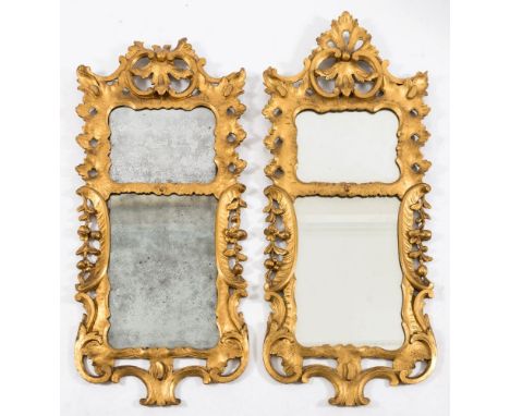 A matched pair of carved giltwood wall mirrors:, with palmette and C scroll crestings and divided cartouche shaped plates, wi