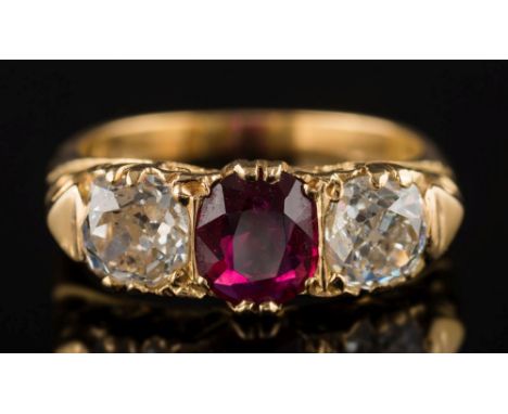 A ruby and diamond three-stone ring:, the central oval ruby approximately 7.5mm x 6.2mm between round old brilliant-cut diamo