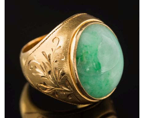 A gentleman's green jade single stone ring: the oval jade approximately 21mm long x 13mm wide x 9.3mm deep and in rub over se