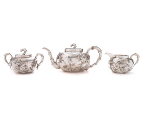 A Chinese silver three piece tea service. maker Wang Hing & Co, Hong Kong: of circular form with low relief decoration of exo