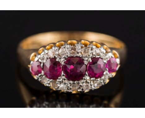 An Edwardian 18ct gold, ruby and diamond elliptical cluster ring: with a central row of five graduated rubies within a surrou