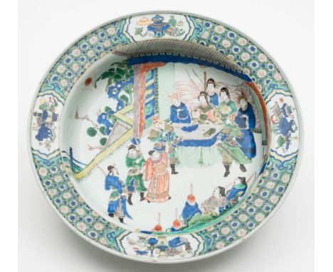 A large Chinese famille verte bowl: finely painted with warriors and other figures in audience before officials seated under 