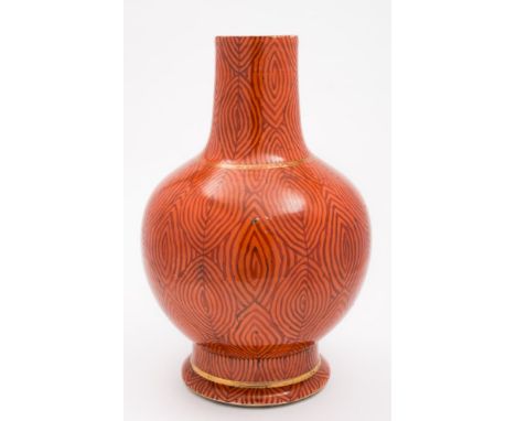 A Chinese 'faux bois' porcelain bottle vase: painted to imitate wood grain on a coral ground, underglaze blue double circles 