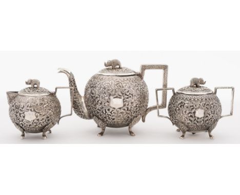 An Indian silver three-piece tea service: of circular form with all over foliate decoration with shield-shaped cartouches, th