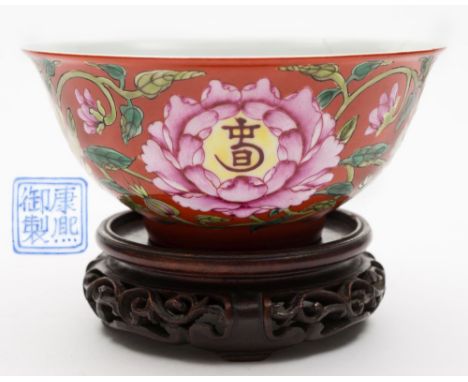 A Chinese porcelain famille rose ruby ground bowl: of circular form with mildly flaring rim, the exterior enamelled with scro