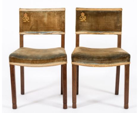 A pair of King George VI Coronation oak chairs:, with curved upholstered backs with G.R. cypher and stuff over saddle seats, 