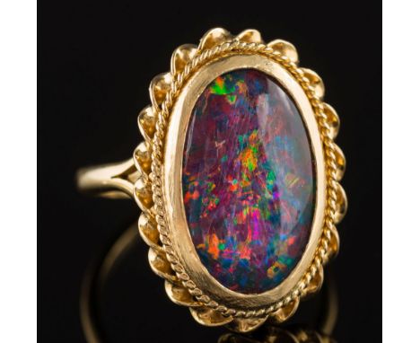 An oval opal triplet single-stone ring:, the shank stamped '18K', 6.5gms gross weight.