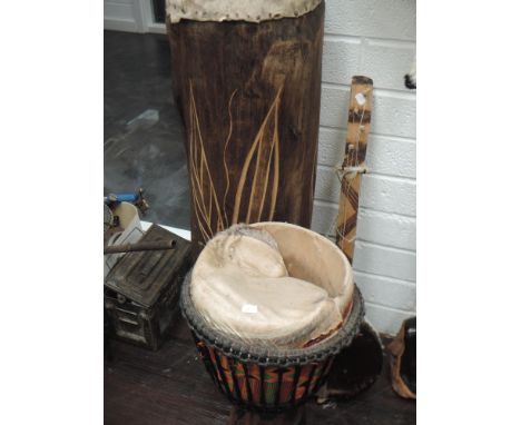 A large African drum, wood and hide, carved decoration, plus a damaged drum and wood string instrument