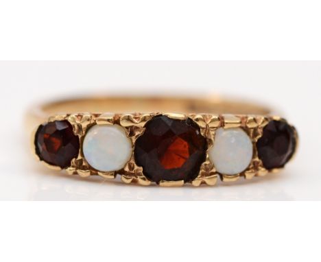 A 9ct gold opal and garnet five stone ring, carved setting, K, 2.3gm 