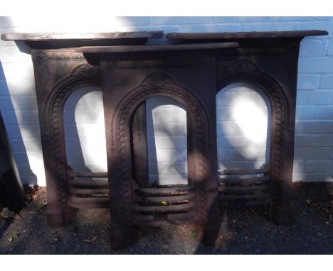 Three Victorian matching cast iron bedroom fire surrounds, one with replacement wooden mantel shelf, each 59cm x 84cm, (3).