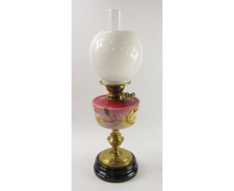 A late 19thC brass and pink opaline glass oil lamp, the reserve painted with roses, white glass shade, 61cm high.