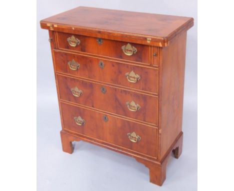 A mahogany and yew wood chest, the fold over top above four graduated drawers, raised on bracket feet, 66cm wide, 33cm deep, 