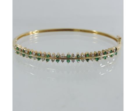 An 18 carat gold emerald and diamond bangle, 6cm diameter