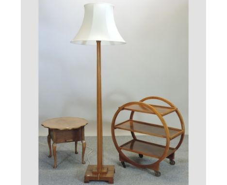 A 1930's walnut drinks trolley, 76cm, together with a similar standard lamp and a serving table, 