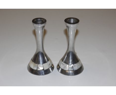 A pair of modernist steel and mother of pearl effect candle holders