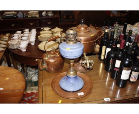 A copper samovar with brass tap; an antique copper tea kettle; a circular copper tray and a Victorian blue ceramic oil lamp