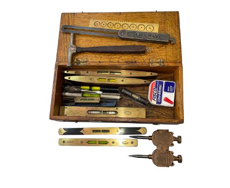 Oak box with vintage spirit levels, mainspring gauge, etc.