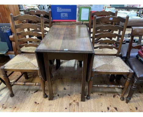 Oak gate leg dining table and set of four rush seated ladder back dining chairs.