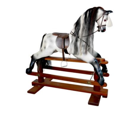 A piebald wooden rocking horse, made by Horseplay, with leather saddle and tack, 127 by 45 by 120cm high.