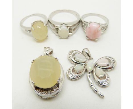 Two silver rings one set with a pink opal and the other a yellow opal, a silver pendant set with a yellow opal, a silver ring