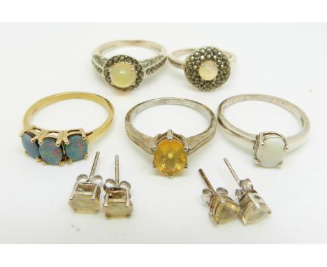 A silver ring set with three opal doublets, two silver rings set with an opal and marcasite, a silver ring set with a fire op