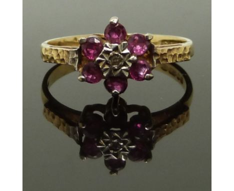 A 9ct gold ring set with rubies and a diamond with textured shoulders, size N, 2.13g&nbsp;