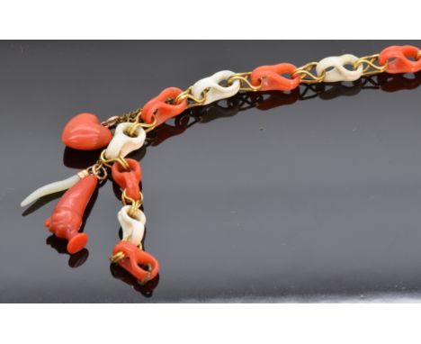 Victorian stick pin made up of alternating coral links, with three charms including heart and mother of pearl