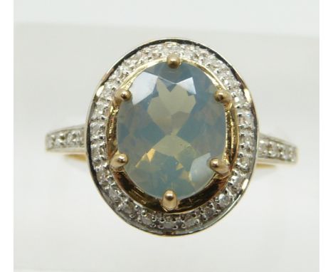 A 9ct gold ring set with an oval cut green fire opal surrounded by diamonds, 3.3g, size N