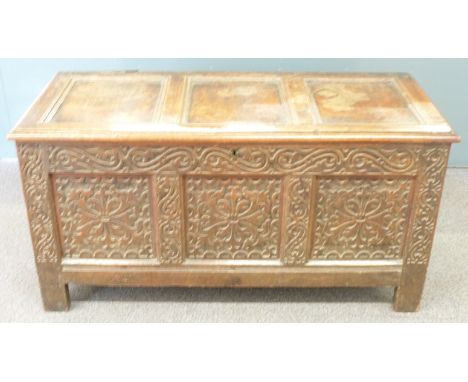 An 18thC oak trunk with carved decoration to the front and sides and panelled lid,&nbsp;W126 x D55 x H65cm