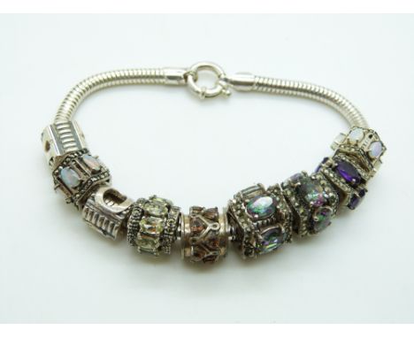 A silver charm bracelet with various charms including topaz, opal, quartz, amethyst, etc&nbsp;