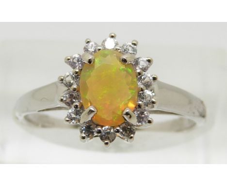 A 9ct white gold ring set with an oval Indonesian opal surrounded by white sapphires, 2g, size N