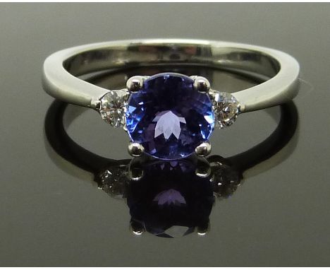 An 18ct white gold ring set with a round cut tanzanite and two round cut diamonds, size K, 2.90g&nbsp;