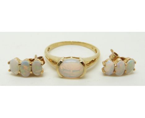 A 9ct gold ring set with an oval opal cabochon (size M/N) and a pair of earrings set with three oval opal cabochons to each, 