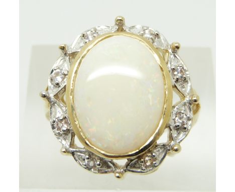 A 9ct gold ring set with an oval Coober Pedy opal cabochon and white sapphires, 7.5g, size N