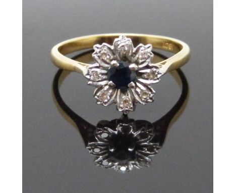 An 18ct gold ring set with a sapphire and diamonds in a flower setting, size P, 3.1g