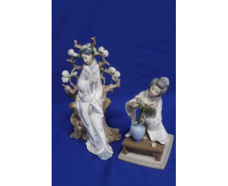 TWO LLADRO GEISHA GIRL FIGURESstanding in front of a flowering tree trunk, the other of a kneeling girl with a flower 