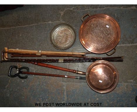 A quantity of copper items including a warming pan, Eastern dish, charger, jam pan and a shooting stick