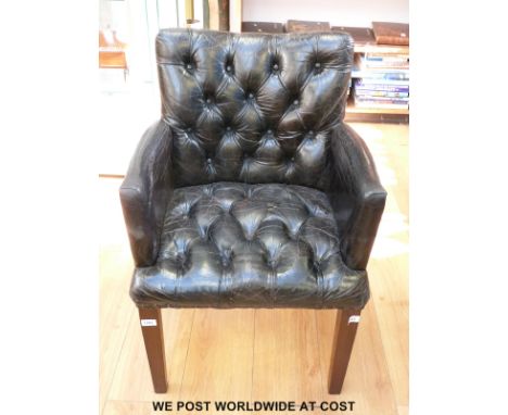 A black leather chair with button back and seat