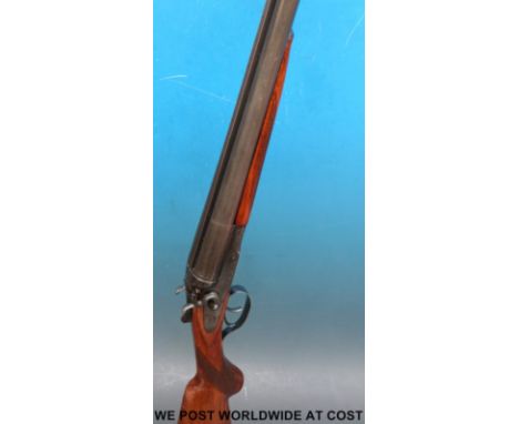 Baikal 12 bore side by side double barrelled hammer action shotgun with engraving of animals to the locks, chequered semi-pis