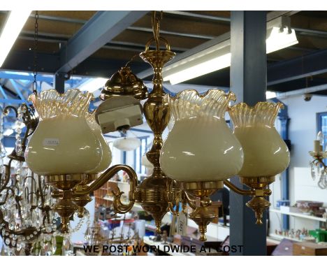 A contemporary five branch brass lamp fitting with glass shades with a pair of matching wall lights, and a bevelled circular 