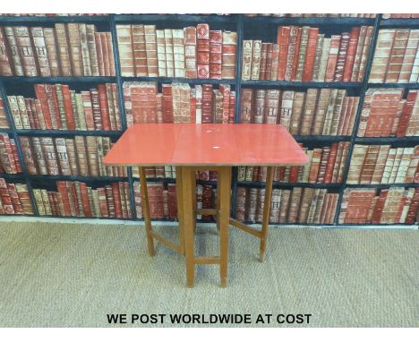 A Formica-topped table, standard lamp and two stools