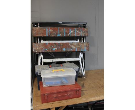 A pair of folding trestle stands together with a folding work bench and metal case, tool boxes and hand tools and hardware 