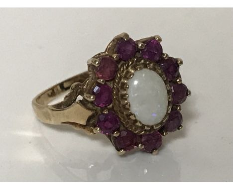 An opal and ruby cluster ring mounted in yellow gold, size P