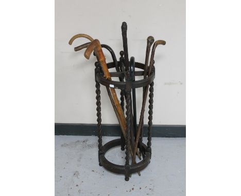 An antique oak barley twist stick stand (no tray) together with seven antique and later walking sticks 