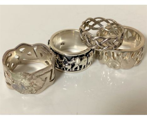 Two silver Celtic knot band rings, a silver spinning ring decorated with elephants and one other 